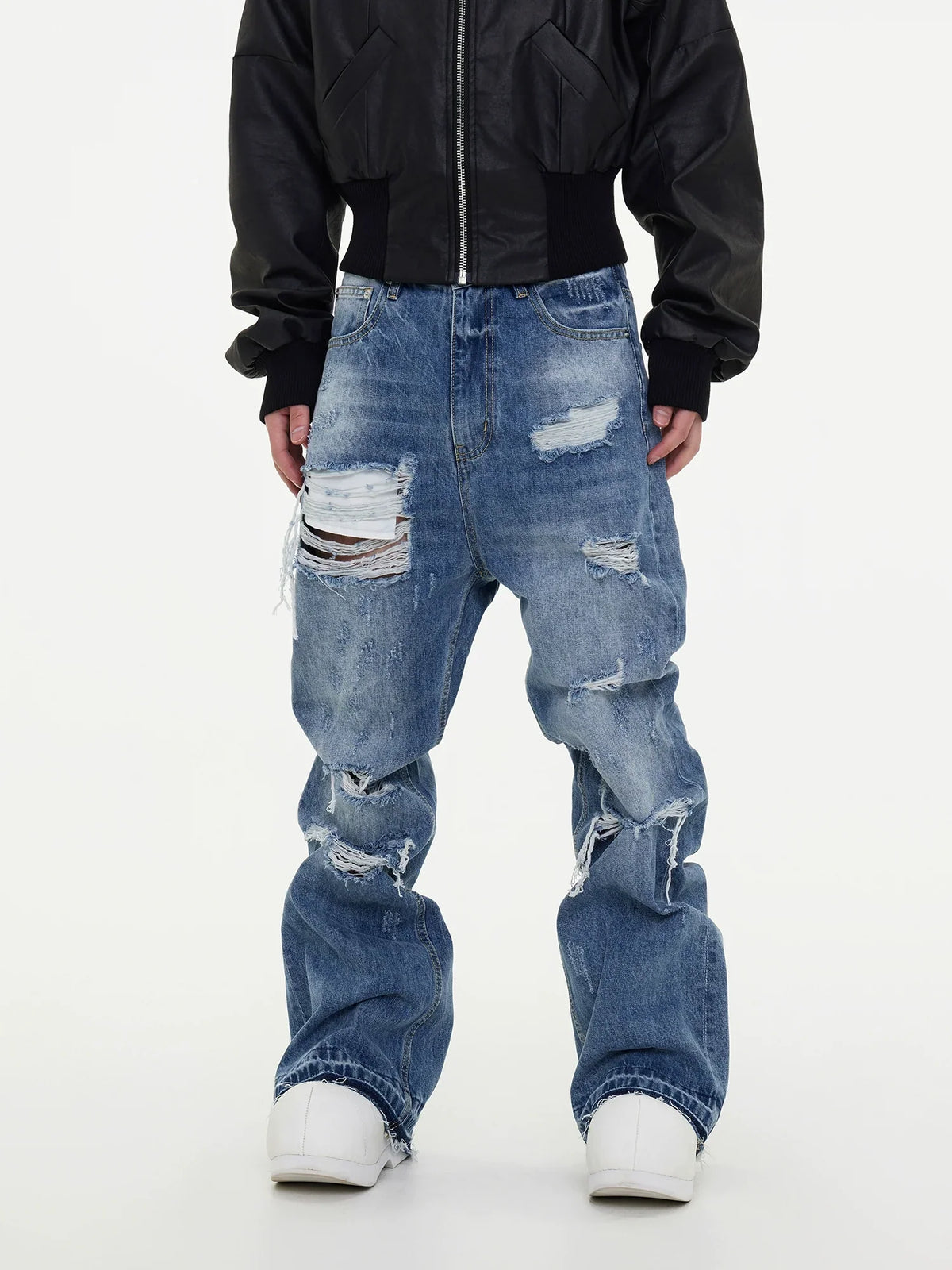 Ripped light-wash distressed baggy jeans styled with a black bomber jacket and white sneakers