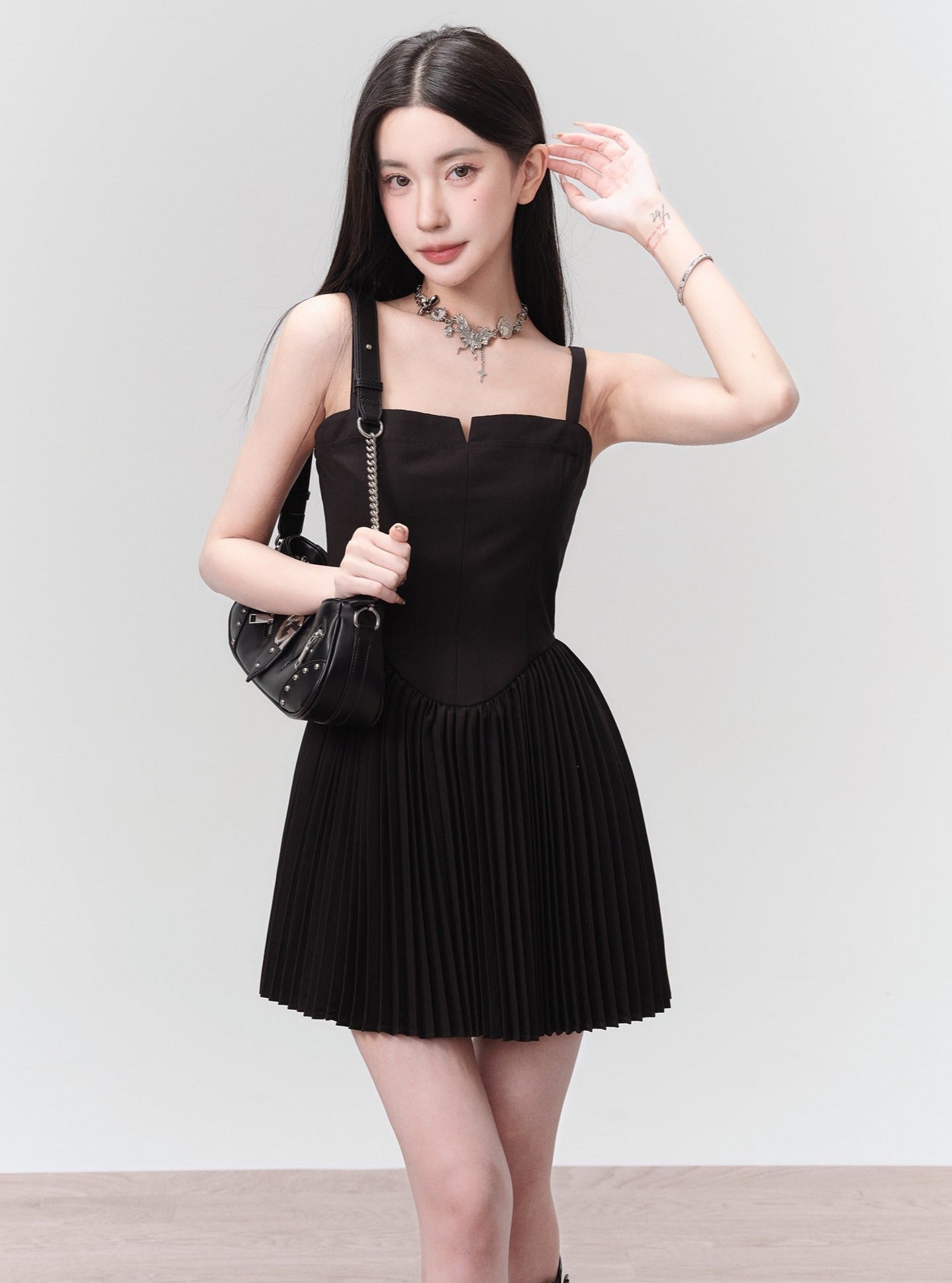 Mini vestido negro plisado con corpiño estructurado