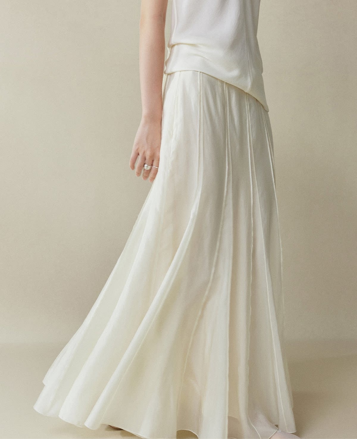 White skirt worn by a person on a plain background