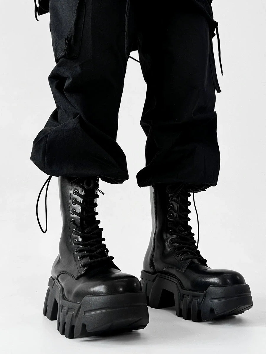 Black lace-up platform combat boots with chunky lug soles, styled with black cargo pants
