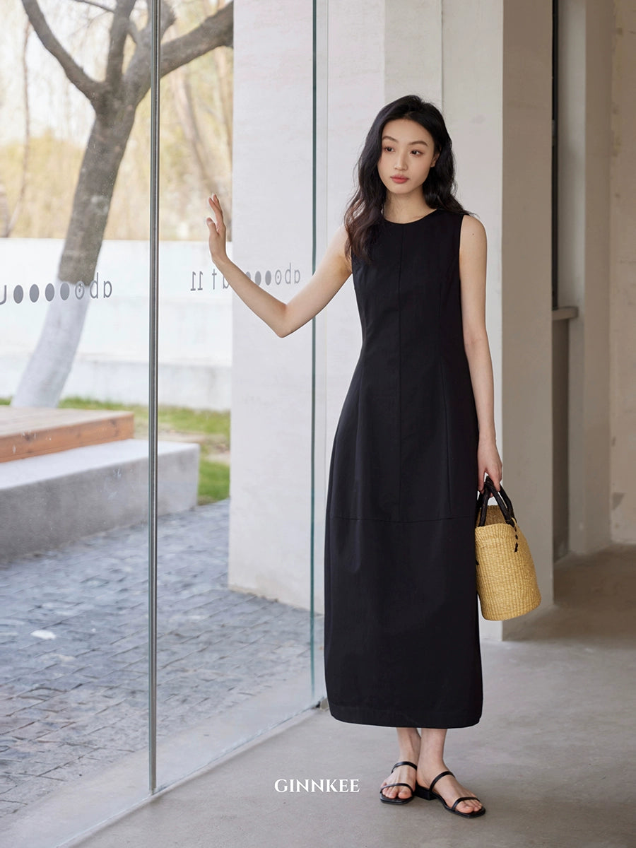 Sleeveless Maxi Dress Paired with a Woven Straw Handbag