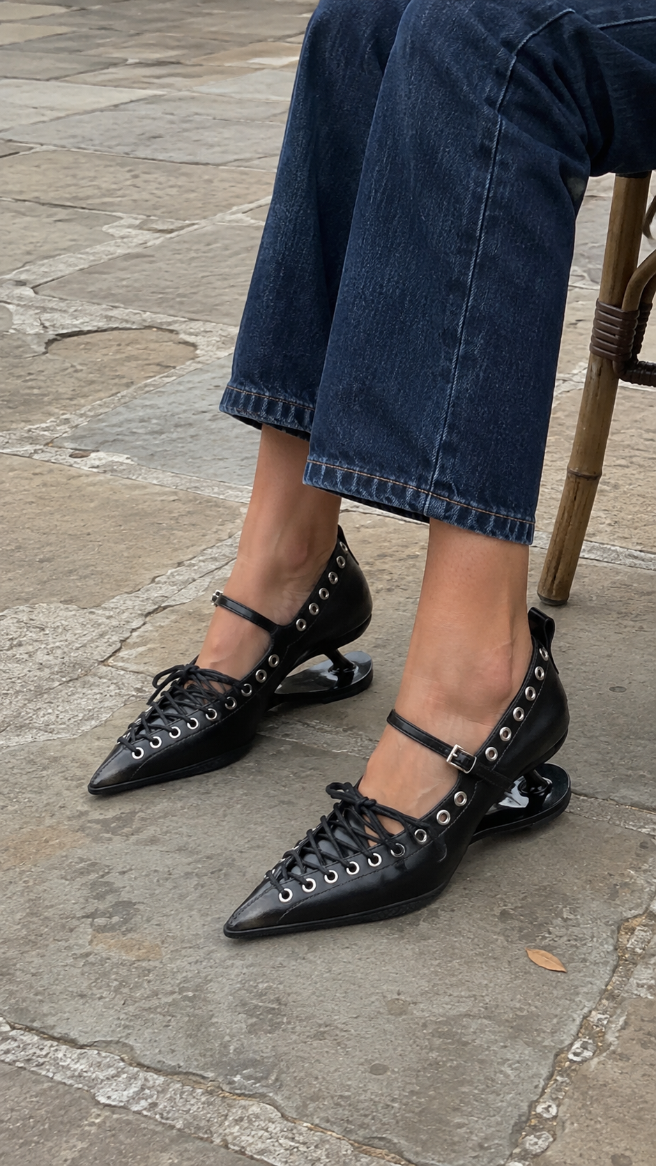 Black Corset-Lace Pointed Stiletto Pumps — café detail; AI-generated lifestyle showcase