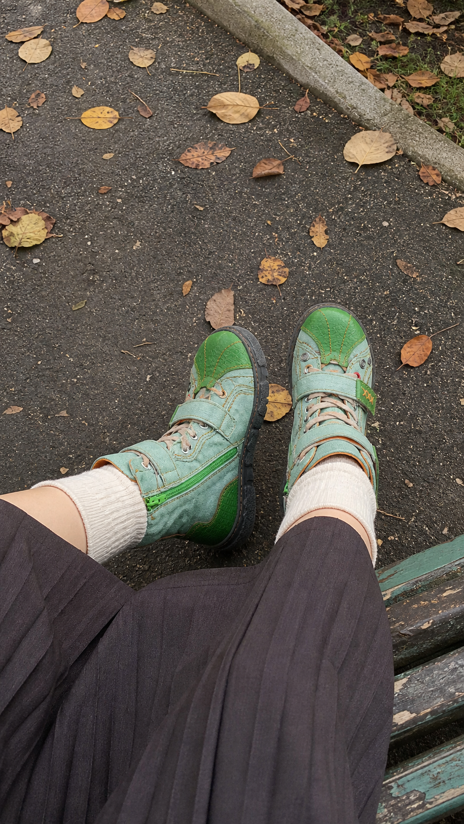 Natural park bench point-of-view photo featuring the mint-green hand-stitched mid-calf boots
