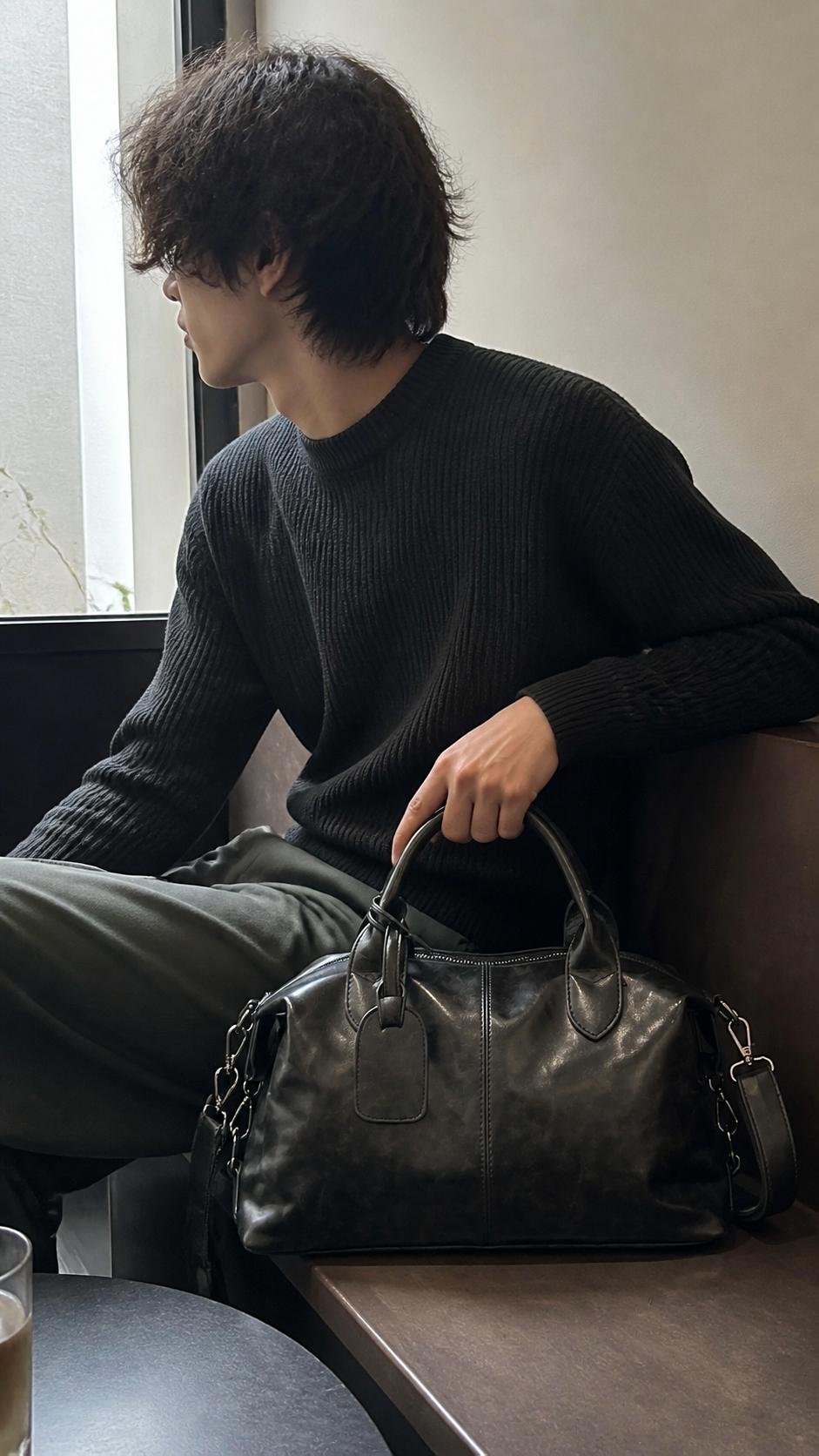 Midnight Transit Leather Weekender beside a casual cafe window seat