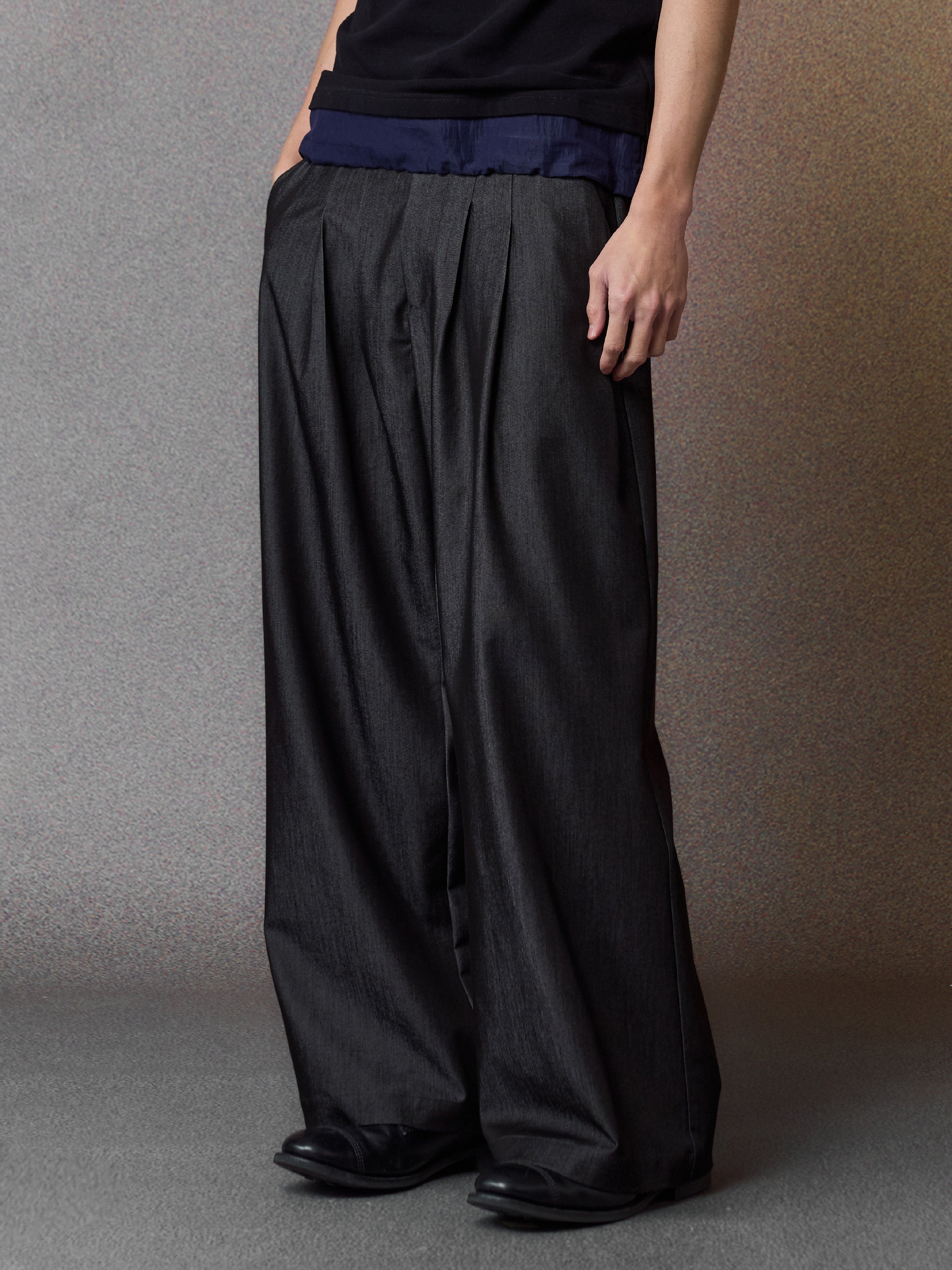 Black pleated wide-leg trousers, front detail
