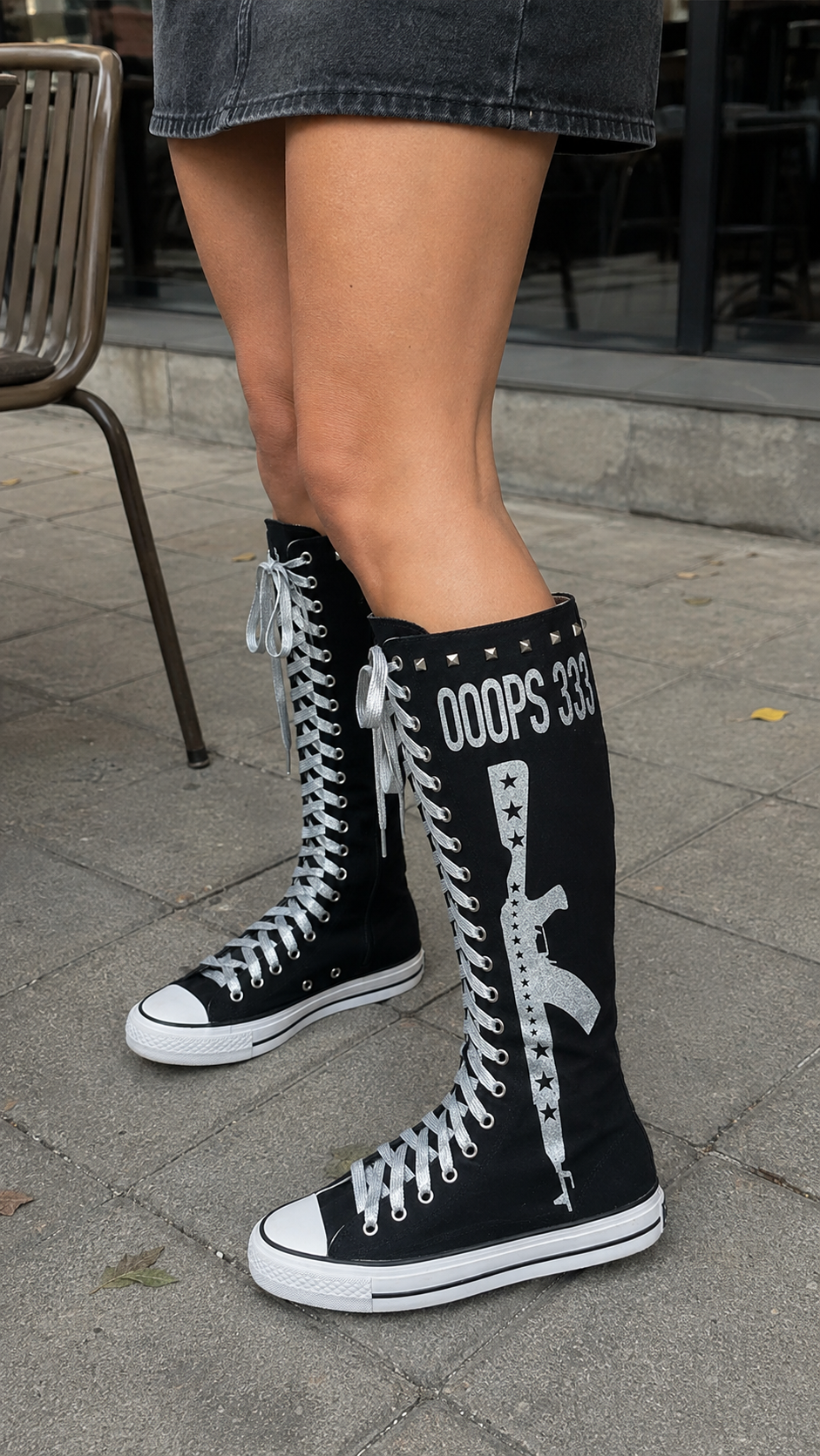 Studded Graphic Canvas Knee-High Boots — Black, café pavement; AI-generated lifestyle showcase