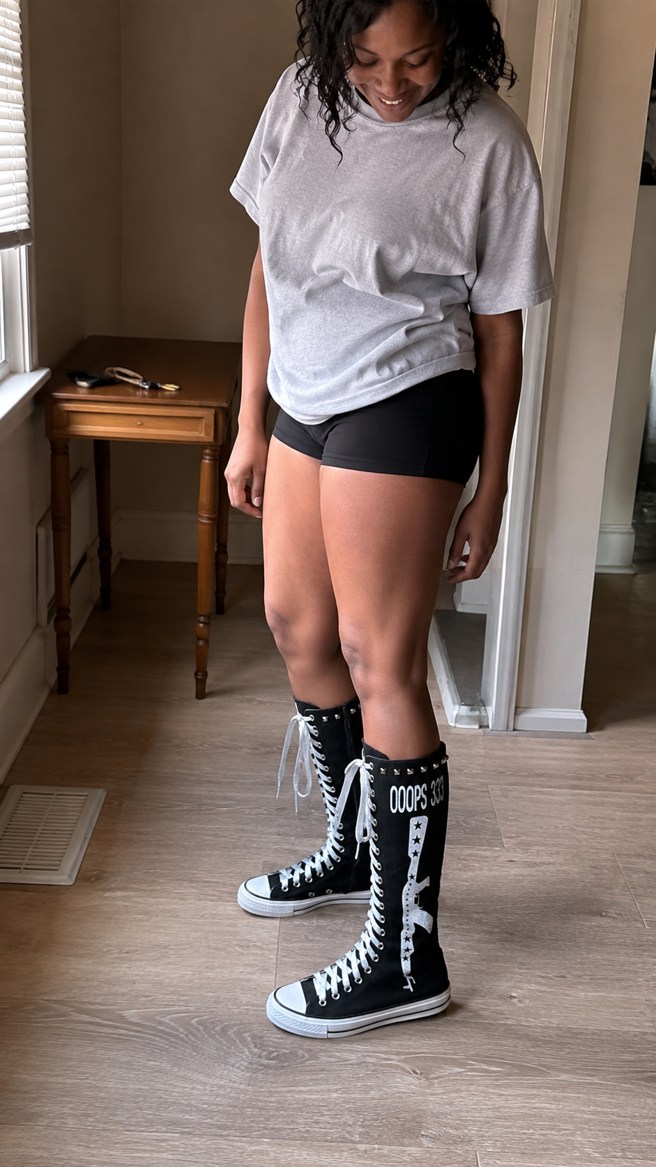Studded Graphic Canvas Knee-High Boots — Black — apartment hallway; AI-generated lifestyle showcase