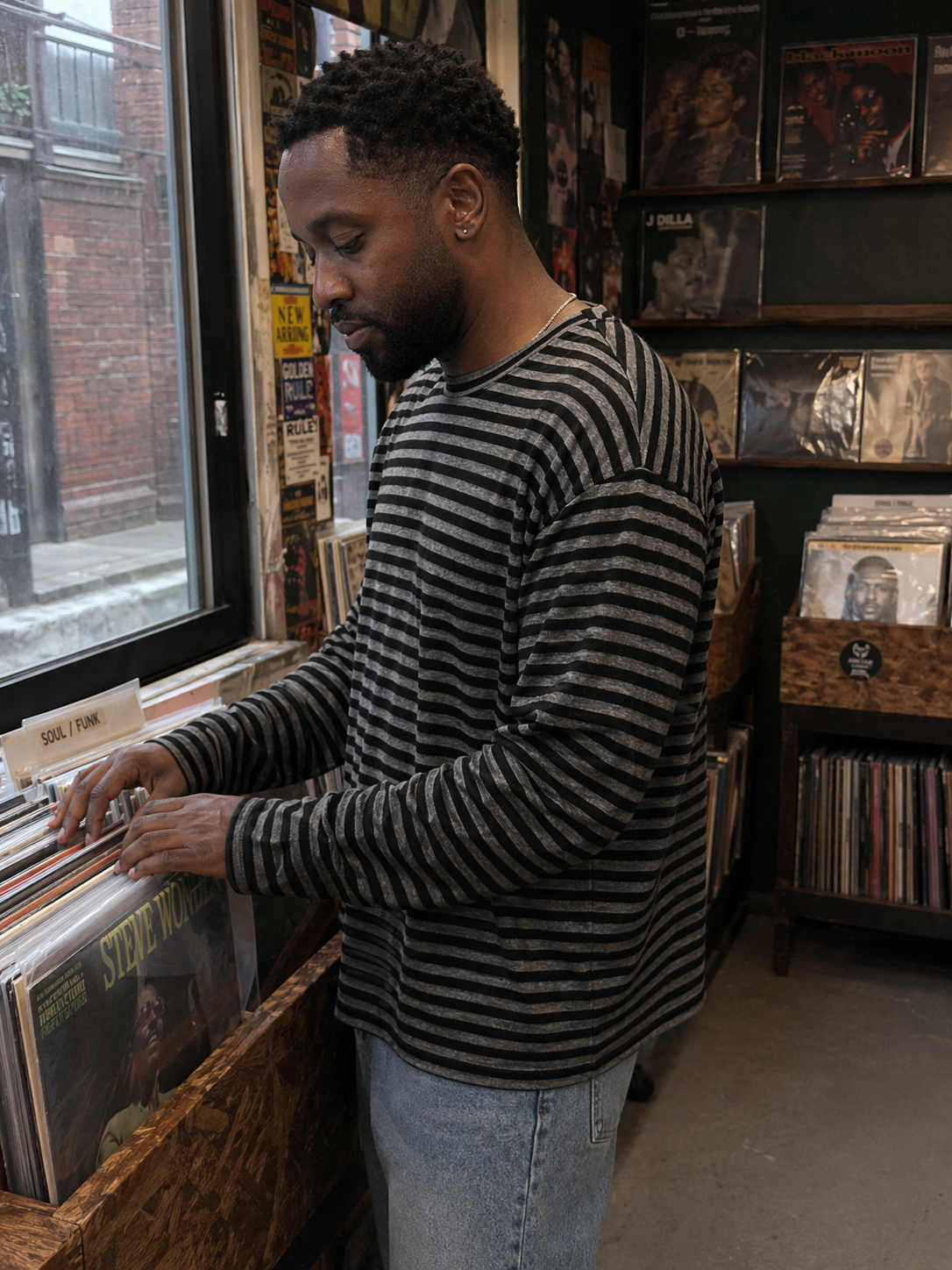 UGC showcase 2 for Tide Slouch Stripe Long Sleeve Tee: Black British man in a London record shop.